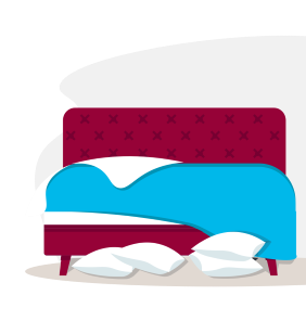 An unmade bed with pillows lying on the floor